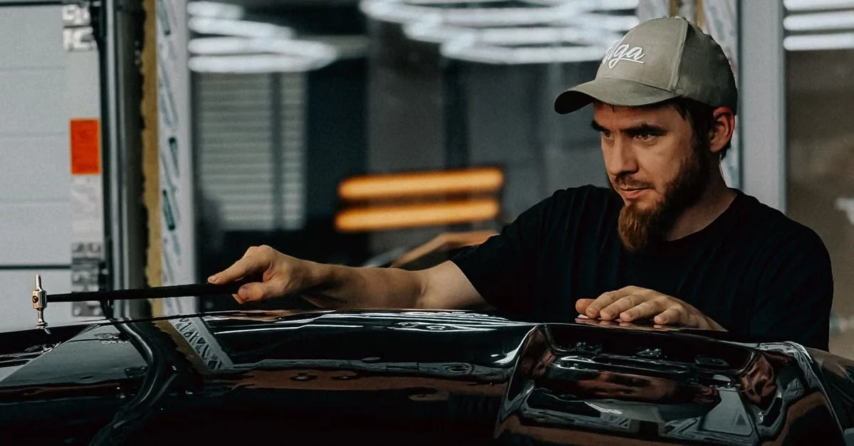 Technician performing precision dent repair on a vehicle panel